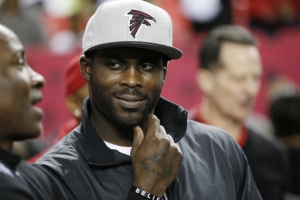 Former Atlanta Falcons quarterback Michael Vick stands on the sidelines before the first half of an NFL football game between the Atlanta Falcons and the New Orleans Saints, Sunday, Jan. 1, 2017, in Atlanta. (AP Photo/John Bazemore)