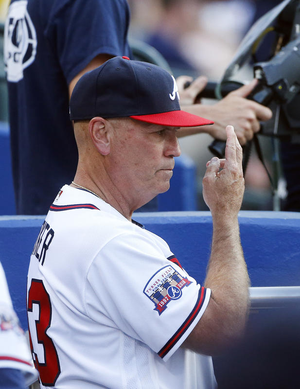 Atlanta Braves interim manager Brian Snitker (43) gives a sign from the dugout during a baseball game against the Milwaukee Brewers on Tuesday, May 24, 2016, in Atlanta. (AP Photo/John Bazemore)