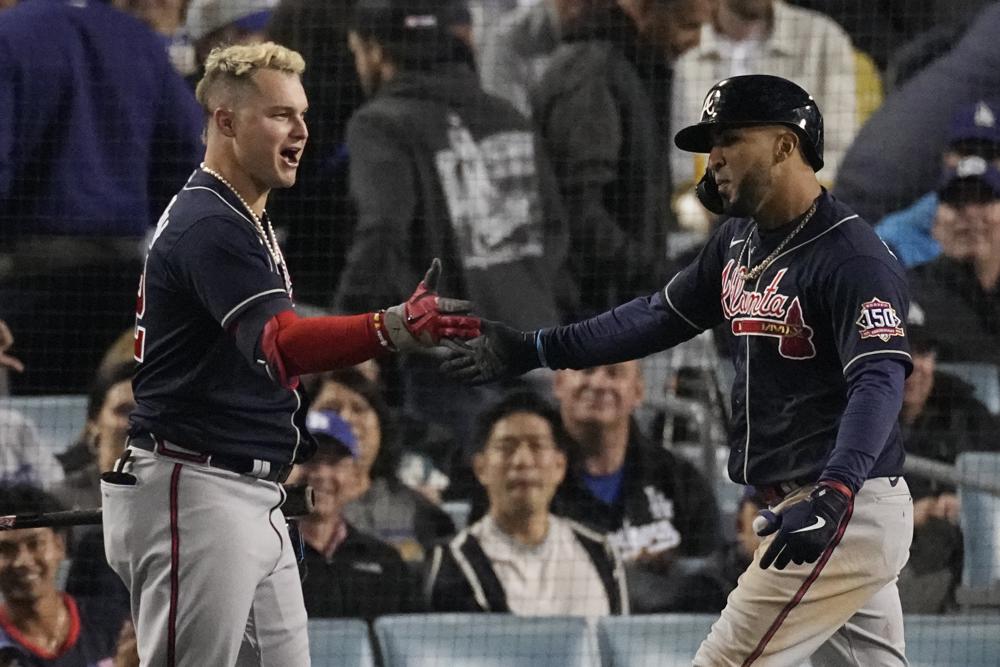 Atlanta Braves' Eddie Rosario, right, is congratulated by Atlanta Braves' Joc Pederson after hitting a two-run home run in the ninth inning against the Los Angeles Dodgers in Game 4 of baseball's National League Championship Series Wednesday, Oct. 20, 2021, in Los Angeles. (AP Photo/Marcio Jose Sanchez)